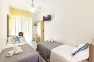 a hotel room with two beds and a television at Hotel Condor-New 2024-Con Piscina in Riccione