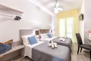 リッチョーネにあるHotel Condor-New 2024-Con Piscinaのベッドルーム1室(ベッド2台、タオル付)