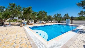 una piscina en un complejo con árboles en el fondo en Fantasy Rooms en Adamas