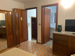 a living room with a television and wooden doors at A... Mare Sicilia in Marina di Modica