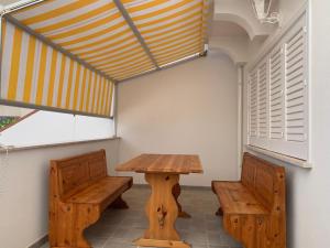 una mesa y dos bancos en una habitación en A... Mare Sicilia, en Marina di Modica