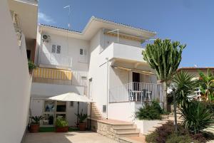 una casa blanca con una palmera delante en A... Mare Sicilia, en Marina di Modica