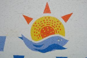a painting of a sun and a whale on a wall at Kokalakis Hotel in Kefalos