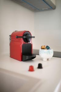 einem roten Toaster, der auf einer Theke neben einer Schüssel sitzt in der Unterkunft Phos Boutique Apartments in Aegiali