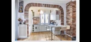 una cucina con banconi bianchi e un muro di mattoni di Queen East Verona apartments a Verona