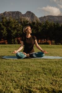 a woman sitting on the grass in a yoga pose at Willa Malinowa in Zakopane +64 photos