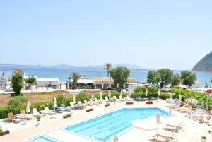 a resort with a pool and chairs and the ocean at Kokalakis Hotel in Kefalos