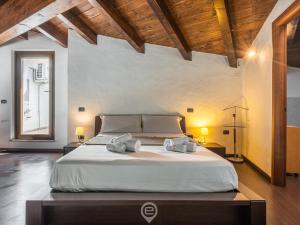 a large bed in a room with wooden ceilings at Estay - Maty's House - AirCon - WiFi - Parking in Gonnesa