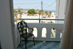 a chair sitting on a balcony looking out at the ocean at Kokalakis Hotel in Kefalos