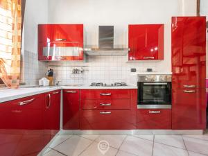 une cuisine rouge avec des armoires rouges et une cuisinière dans l'établissement Maty's House, à Gonnesa 16 autres photos