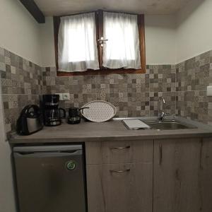 a kitchen with a sink and a counter top at Glyfada Bay Studios in Varlamaíika