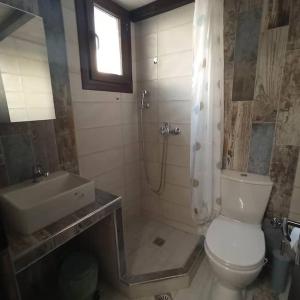 a bathroom with a toilet and a sink and a shower at Glyfada Bay Studios in Varlamaíika +47 photos