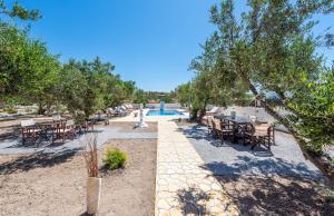 a resort with a pool and tables and chairs at Fantasy Rooms in Adamantas