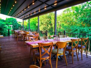 um restaurante com mesas e cadeiras num deque em Hotel Laguna Terrace em Kavarna