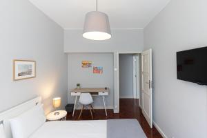 a bedroom with a bed and a desk at Lolla's City House in Porto