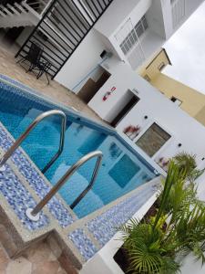 een uitzicht op een zwembad in een huis bij Hostal Las Orquideas in Manta