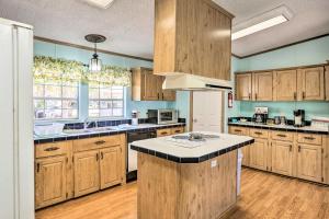 a kitchen with wooden cabinets and a white refrigerator at Steinhatchee Home with Boat Parking 1 Mi to Marina in Steinhatchee