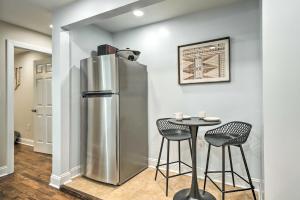 a kitchen with a stainless steel refrigerator and a table at Takoma Park Apt with Wood Fire Pit Less Than 8 Mi to DC in Takoma Park