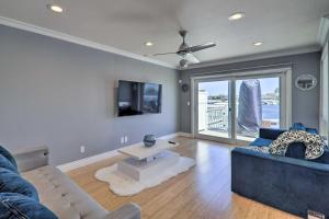 a living room with a couch and a tv and a table at Discovery Bay Retreat with Balcony and Boat Dock! in Discovery Bay