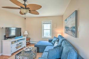 een woonkamer met een blauwe bank en een flatscreen-tv bij Bliss on the Bay Near Seaside Heights Beach in Seaside Heights
