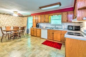 a kitchen with wooden cabinets and a table and chairs at Dale Hollow Lake Haven Private Yard and Grill! in Albany