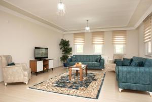 Al Jannah Residence في طرابزون: غرفة معيشة مع كنبتين زرقاوين وطاولة