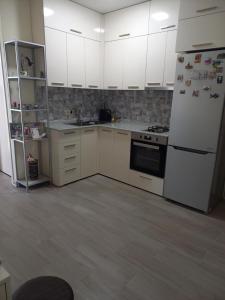 een keuken met witte kasten en een witte koelkast bij Tamas house in Batoemi
