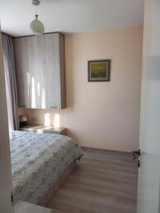 een slaapkamer met een bed en een foto aan de muur bij Tamas house in Batoemi