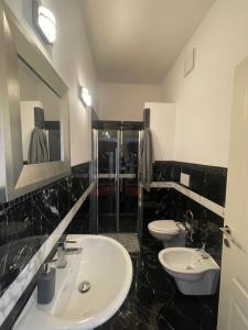 uma casa de banho em preto e branco com 2 lavatórios e um espelho em Villa Bianca a pochi passi dal mare con giardino esclusivo em Livorno