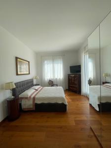 um quarto com uma cama grande e um espelho em Villa Bianca a pochi passi dal mare con giardino esclusivo em Livorno