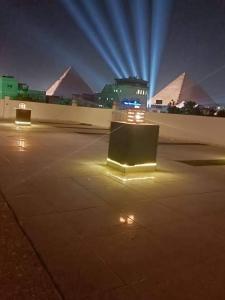 een parkeerplaats 's nachts met piramides op de achtergrond bij Nefertiti pyramids view in Caïro
