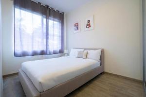a white bedroom with a large bed with a window at Lotus Stay Manly - Apartment 29C in Sydney