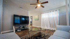 uma sala de estar com um sofá e uma televisão de ecrã plano em Elegant Cozy Oasis on a traffic free street em Clearwater