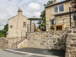 un edificio de piedra con un paraguas encima en Box Tree Cottage, en Keighley