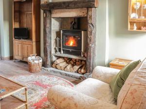 a living room with a fireplace and a couch at Box Tree Cottage in Keighley