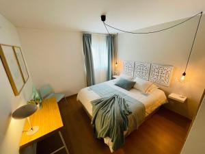 1 dormitorio con 1 cama, 1 mesa y 1 lámpara en Fantástico apartamento T2 a 2min do acesso à praia CozyIn Cabanas, en Cabanas de Tavira