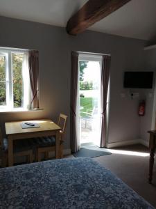 um quarto com uma cama, uma mesa e uma janela em Risley Guest House em Risley