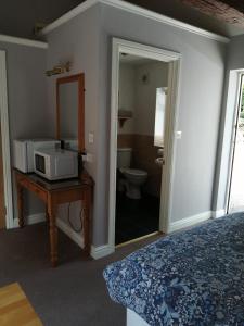 a bedroom with a bed and a microwave on a table at Risley Guest House in Risley