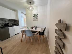 een keuken en eetkamer met een tafel en stoelen bij LE COSY Résidence du Golf in Deauville