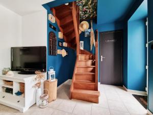 een trap in een kamer met een blauwe muur bij La Tiny proche lac et forêt in Sillé-le-Guillaume