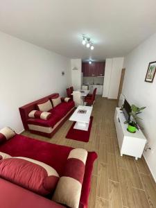 een woonkamer met een rode bank en een tafel bij Apartment Vasilije in Žabljak