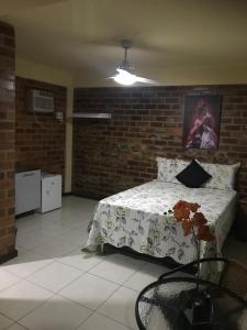 a bedroom with a bed and a brick wall at Pousada OASIS DO BARRAL in Rio de Janeiro