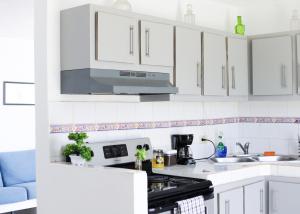 a kitchen with white cabinets and a stove top oven at Marina House in Arroyo