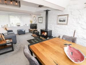 a living room with a wooden table and a fireplace at The Sail Loft in Porthmadog