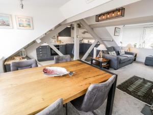 una sala da pranzo con tavolo e sedie in legno di The Sail Loft a Porthmadog