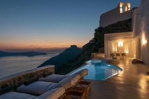 a villa with a pool and a view of the ocean at Villa Dio - An Iconic Villa Above Caldera in Firostefani +23 photos
