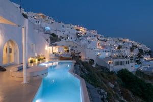 a villa with a swimming pool at night at Villa Dio - An Iconic Villa Above Caldera in Firostefani