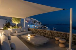 a living room with a view of the ocean at night at Villa Dio - An Iconic Villa Above Caldera in Firostefani