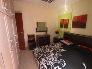 um quarto com uma cama em preto e branco e uma televisão em Διαμέρισμα για 4 με θέα θάλασσα σε ήσυχη γειτονιά em Chalkida