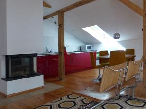 a kitchen with red cabinets and a living room at Villa am Trumpf - Design-Appartements im Naturgarten am See in Melzow
